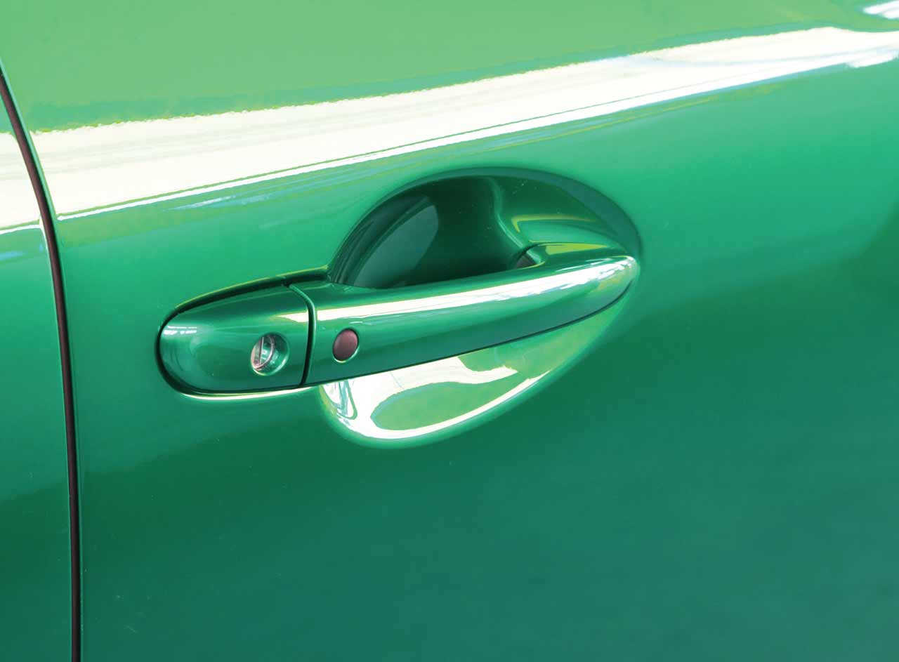 Platinum Gloss PPF Series on the door handle of a green car